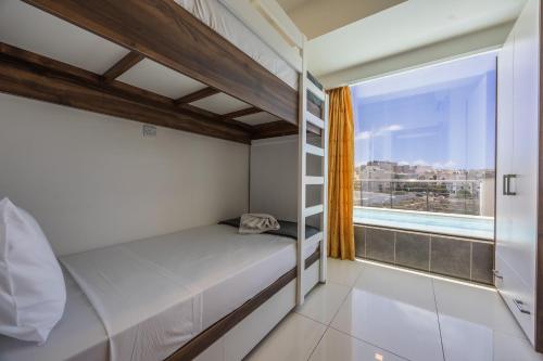 a bedroom with a bunk bed and a window at Mellieha Penthouse with pool and view by Homely in Mellieħa