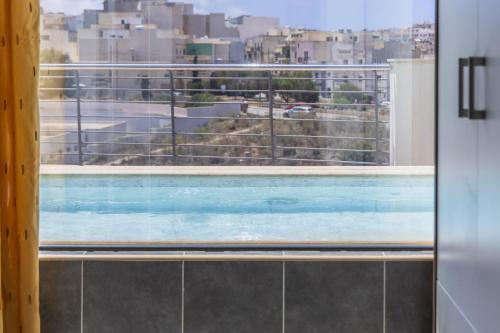 a view of a swimming pool from a window at Mellieha Penthouse with pool and view by Homely in Mellieħa