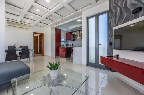 a living room with a glass table and a kitchen at Mellieha Penthouse with pool and view by Homely in Mellieħa