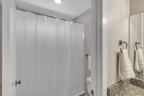a white bathroom with a shower and a toilet at The Ideal Getaway home in Cedar City
