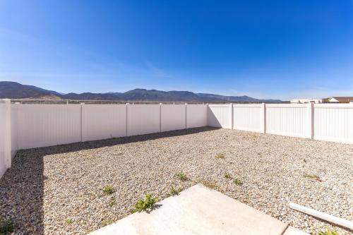 a backyard with a white fence and gravel at The Ideal Getaway home in Cedar City