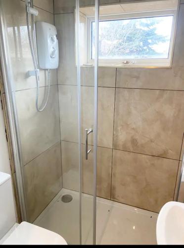 a shower with a glass door in a bathroom at Beautiful 4 Bedroom 2 bathroom House close to city centre in Leeds