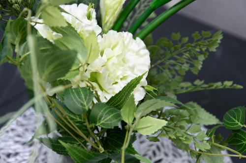 a vase filled with white flowers and green plants at Mova Villa Ozu in Ozu