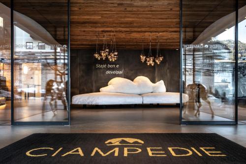 a bedroom with a white bed in a room at Ciampedie Luxury Alpine Spa Hotel in Vigo di Fassa