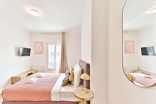 une chambre blanche avec un lit et un miroir dans l'établissement Studio cosy proche de la capitale - Montreuil, à Montreuil