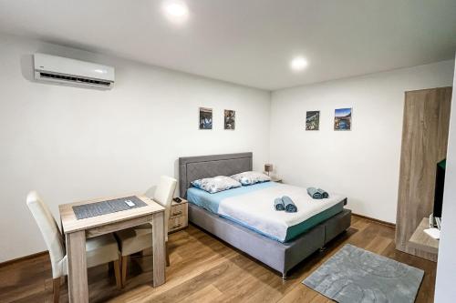 a bedroom with a bed and a table and a desk at Studio Apartments Rio Verde in Mostar