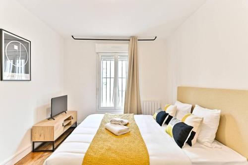 une chambre avec un grand lit et une télévision dans l'établissement Magnifique studio banlieue Parisienne - Montreuil, à Montreuil