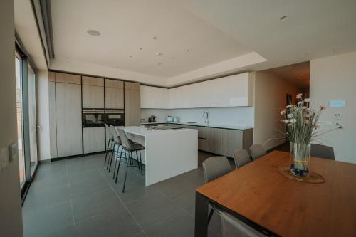 a kitchen with white cabinets and a table and chairs at Villa Enchante - Heated Outdoor Pool in Mellieħa