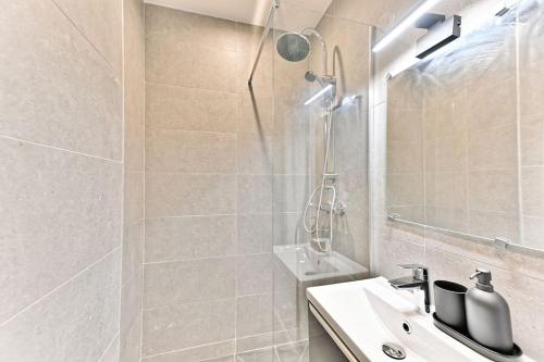 une salle de bain blanche avec une douche et un lavabo dans l'établissement Studio neuf spacieux et lumineux - Montreuil, à Montreuil