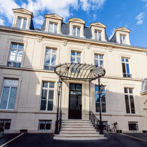 un grand bâtiment blanc avec des escaliers devant lui dans l'établissement La Rêverie - Deluxe Apartment - SPA - Place du Forum, à Reims