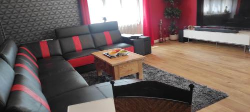 a living room with a black couch and a table at maison grand parking privé in Tournon-Saint-Martin