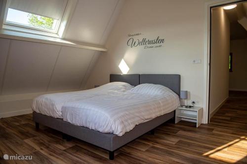 a bedroom with a bed with a white comforter at Erve Schuurboer in Tilligte