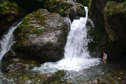 a woman standing in front of a waterfall at Dariani Cottage in Oni