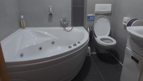 a bathroom with a white tub and a toilet at Hotel Irish in Bihać