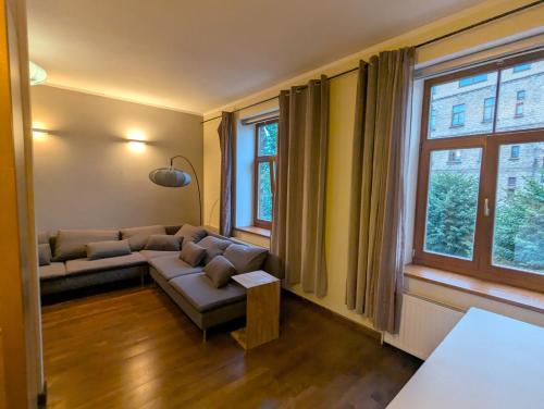 een woonkamer met een bank en een raam bij Midcentury modern, quiet, 40m studio with bath in Rīga