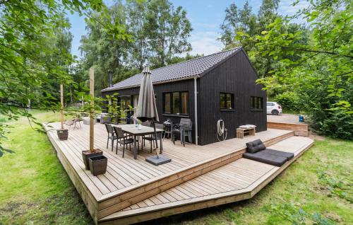 a house with a deck with a table and an umbrella at Nice Home In Ebeltoft With Wifi in Ebeltoft