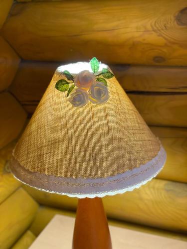 a lamp with a flower on the top of it at Еко котедж Яблуницька троянда in Yablunytsya