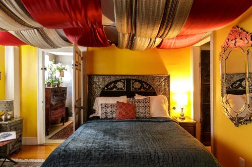 a bedroom with a large bed with yellow walls at Moroccan Boutique Guest House in Boston