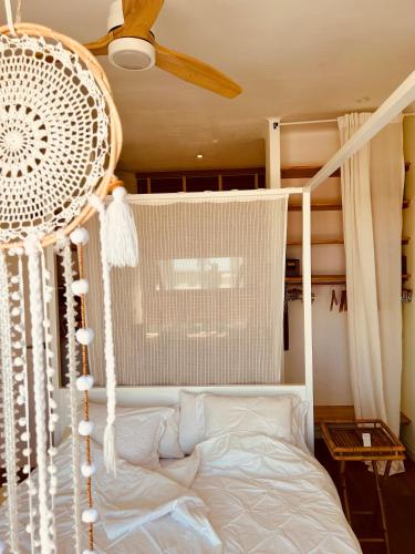 a bedroom with a white bed with a fan at Casa Viva Begur in Begur