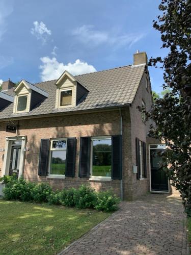 a brick house with windows and a roof at Lis de Maison in Bergentheim