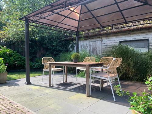 a patio with a table and chairs under a canopy at Lis de Maison in Bergentheim