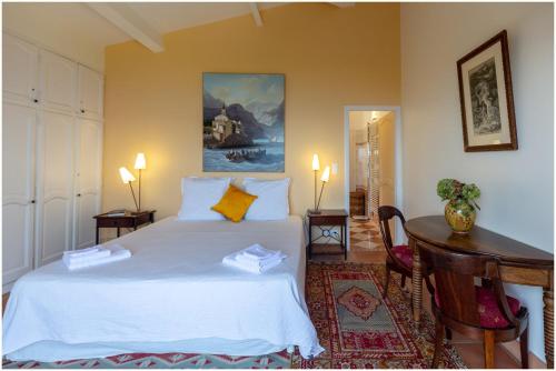 une chambre avec un grand lit blanc et un bureau dans l'établissement Villa Mare e Monti, à Coti-Chiavari