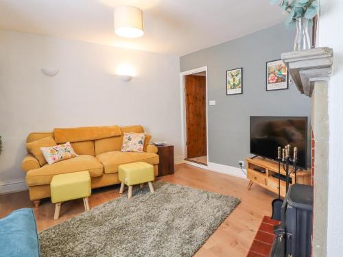a living room with a couch and a tv at Birch Cottage in Skipton