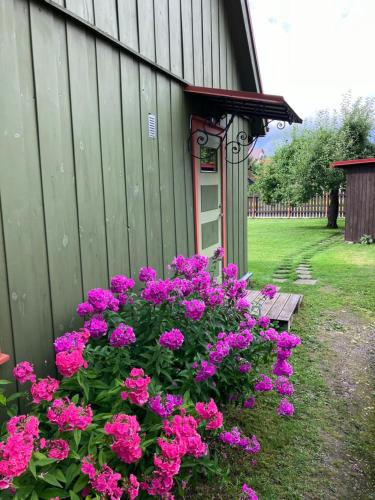un giardino con fiori rosa e una panchina accanto a un edificio di Arkaadia a Viljandi