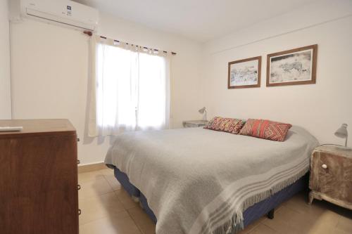a white bedroom with a bed and a window at M. BERNARD in Concordia