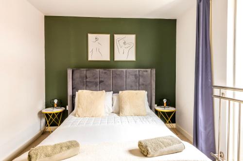 a bedroom with a large bed with green walls at Centralised Abbey Yard by Prescott Apartments in Abingdon