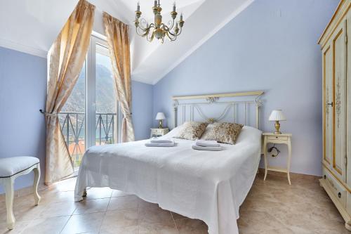 a bedroom with a large white bed and a window at Apartmani with POOL and VIEW in Gornji Orahovac
