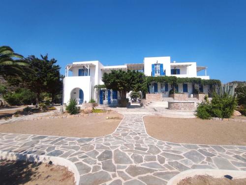 a large white house with a stone walkway at Villa Le Grand Bleu in Katapola