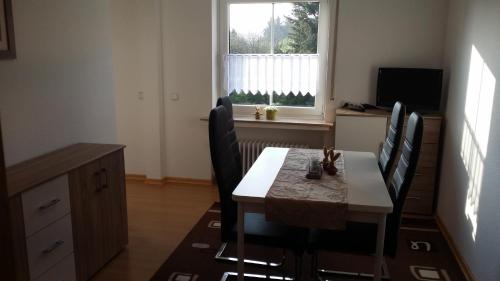 a dining room with a table and chairs and a window at Ferienwohnung Debray in Winterberg