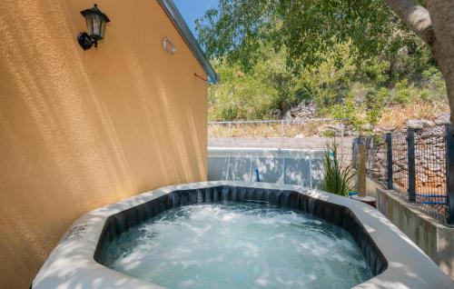 a hot tub in the backyard of a house at 6 Bedroom Awesome Home In Prolozac in Donji Proložac