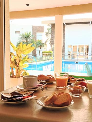 een tafel met borden eten naast een zwembad bij Altos de Alem in Federación