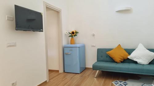 a living room with a blue couch and a tv at Casa delle Luci - garage incluso in Maiori