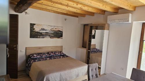 Un dormitorio con una cama y un refrigerador dentro. en Bucaneve, en Laino