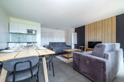 une cuisine et un salon avec une table et des chaises dans l'établissement Appartement Familial Confortable proche de Paris, aux Lilas