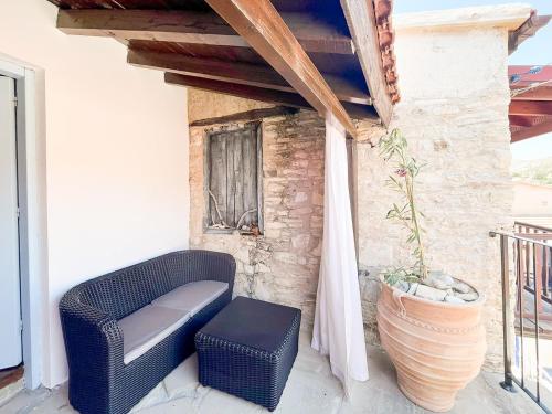 a wicker chair and stool sitting on a porch at Kalavasos Square Apartments - With Access to Shared Pool 3 Minutes Walk in Kalavasos