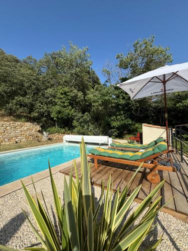 un patio avec un parasol et des chaises et une piscine dans l'établissement La Grange de Paulette, à Bédoin