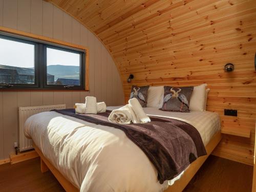 a bedroom with a large bed in a log cabin at Heron in Carnforth