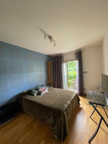 une chambre avec un lit et une table en verre dans l'établissement Appartement traversant avec balcon et belle vue sur jardin, proche des commodités et à moins de 30 minutes de Paris en transport, à Chennevières-sur-Marne