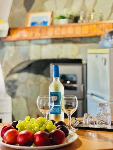 a plate of grapes and a bottle of wine on a table at Artemis Traditional House in Kerames