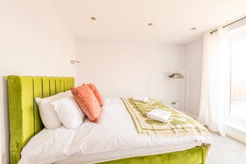 a bed with a green headboard in a white room at Luxury Pent House Apartment - Central - 6 Guests in Abingdon