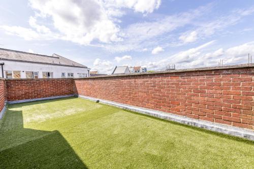 a brick wall with a lawn in the middle of it at Luxury Pent House Apartment - Central - 6 Guests in Abingdon