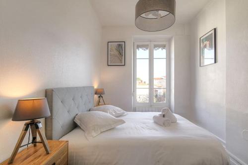 une chambre avec un lit avec une lampe et une fenêtre dans l'établissement Bel appartement lumineux, Croix-Rousse - Hôpitaux, à Lyon