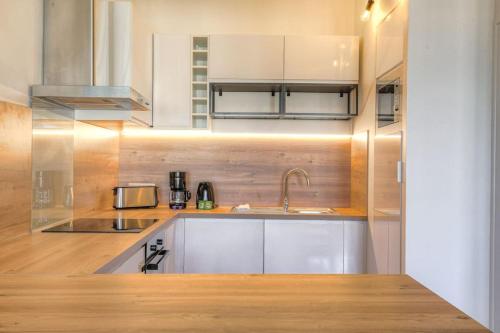 une cuisine avec des armoires blanches et un évier dans l'établissement Bel appartement lumineux, Croix-Rousse - Hôpitaux, à Lyon