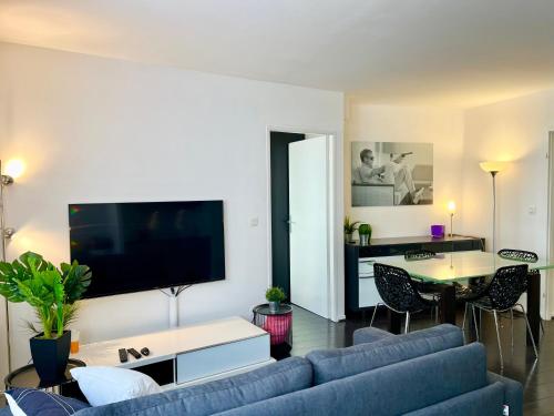 un salon avec un canapé bleu et une télévision dans l'établissement Le Forville Centre avec Parking, à Reims