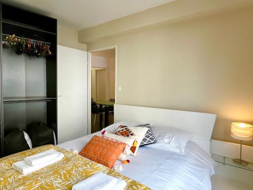 une chambre avec un lit avec des oreillers dessus dans l'établissement Le Forville Centre avec Parking, à Reims