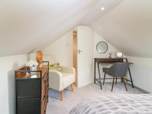 a bedroom with a bed and a desk and a chair at 7 High Buckholmside in Galashiels